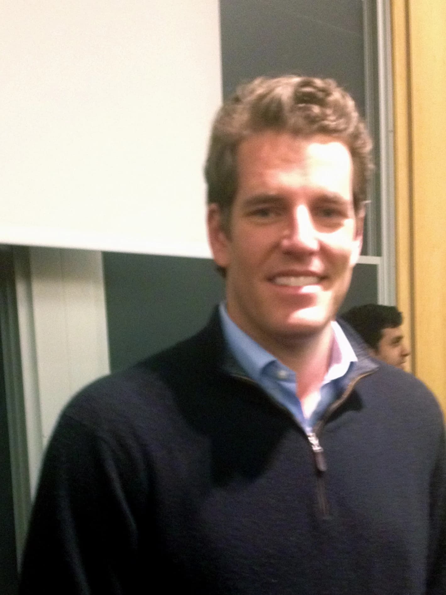 Tyler Winklevoss, co-founder of Winklevoss Capital Management, smiles indoors.