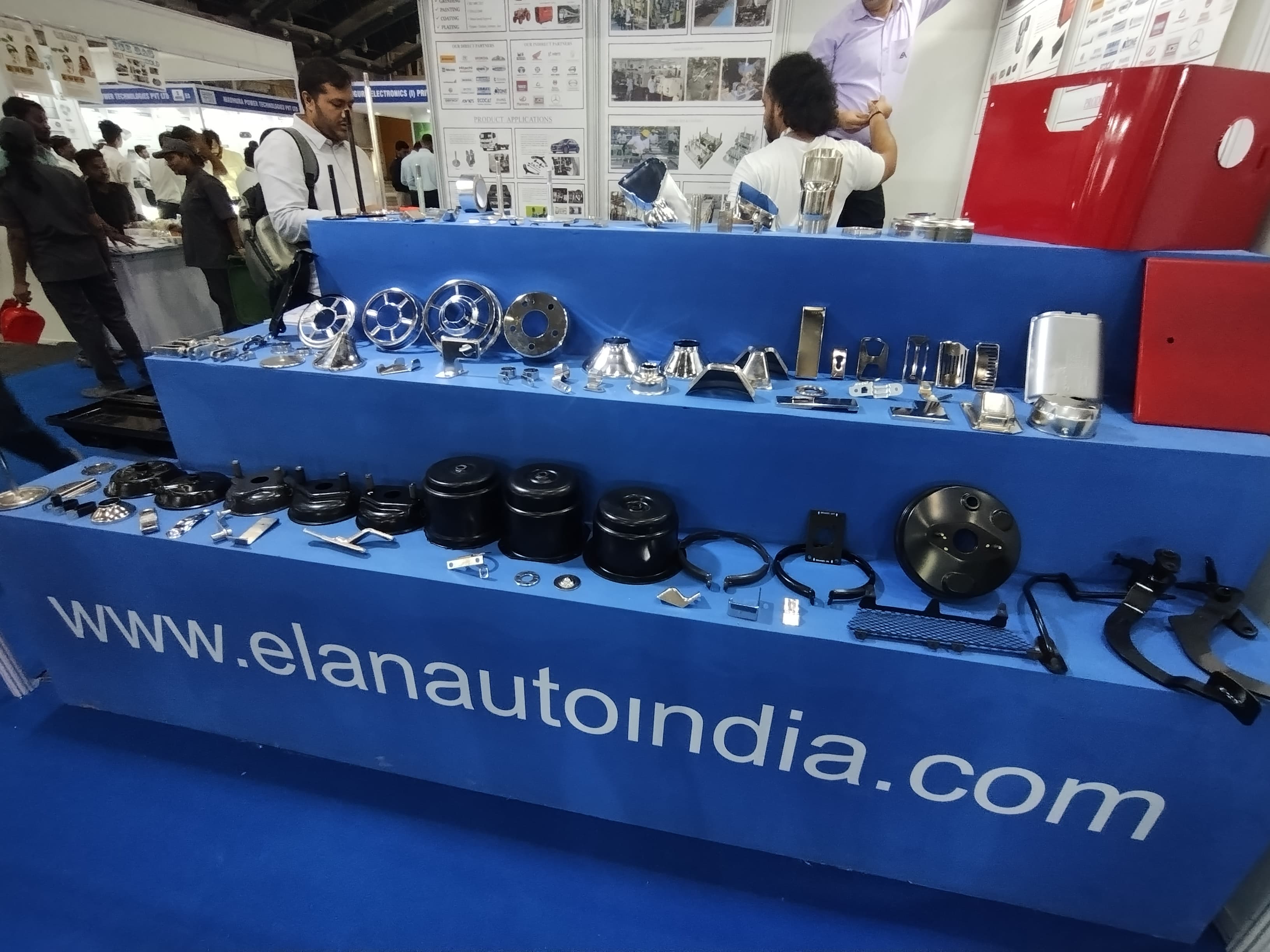 Exhibition booth displaying various automotive components and parts at an expo.