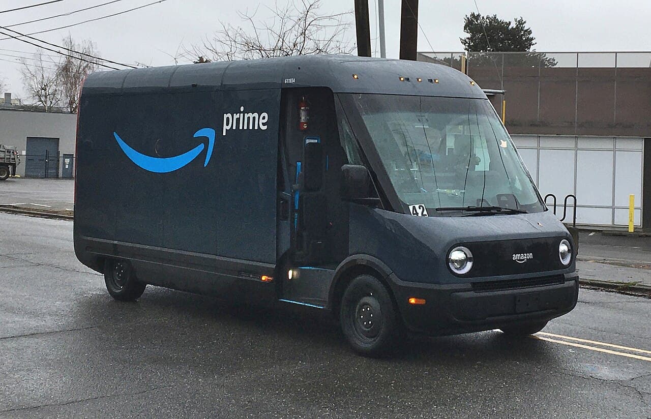 Rivian EDV-700 electric delivery van with Amazon Prime branding on a street.