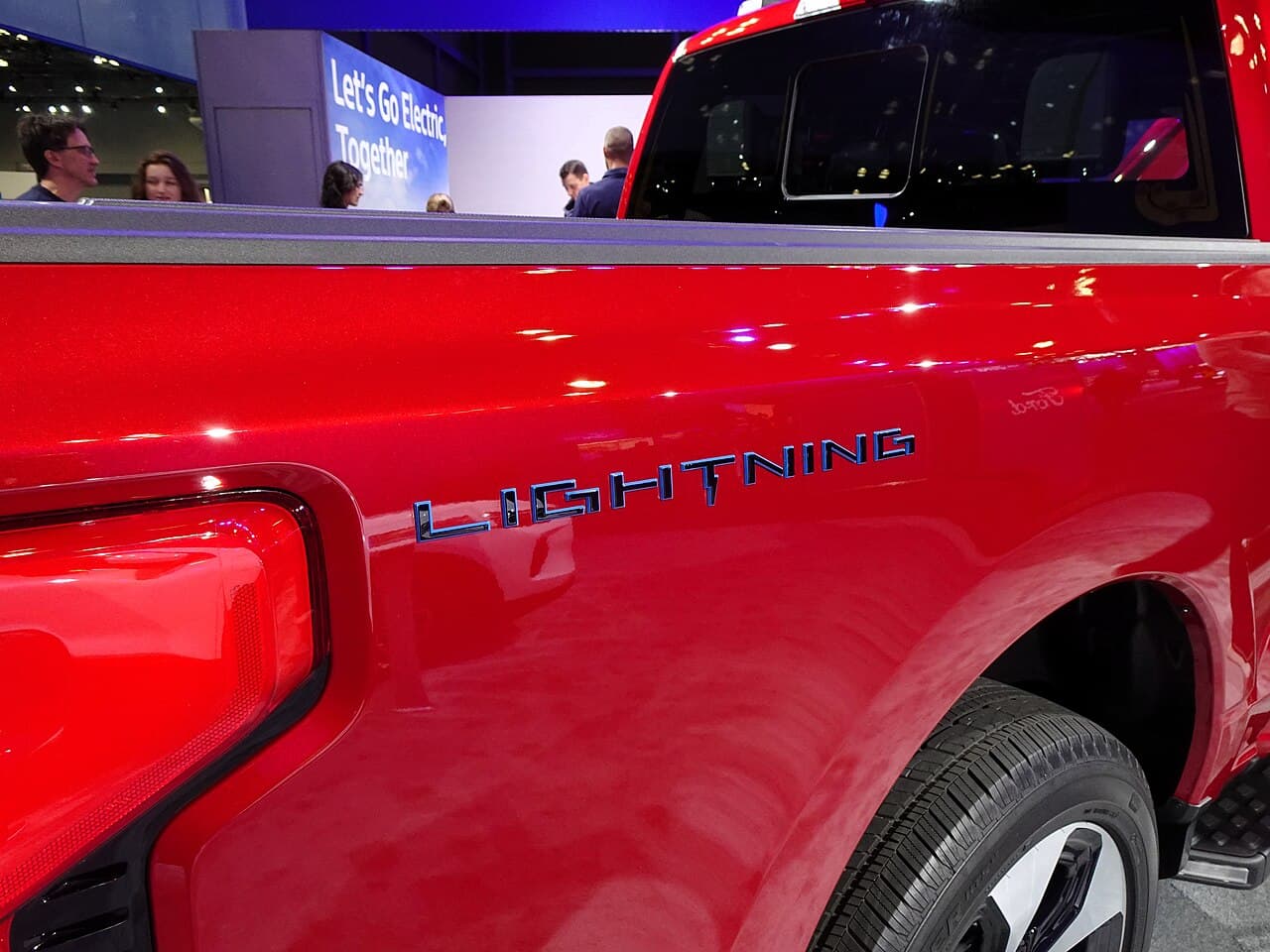Close-up of the Ford F-150 Lightning Platinum electric pickup truck in red.