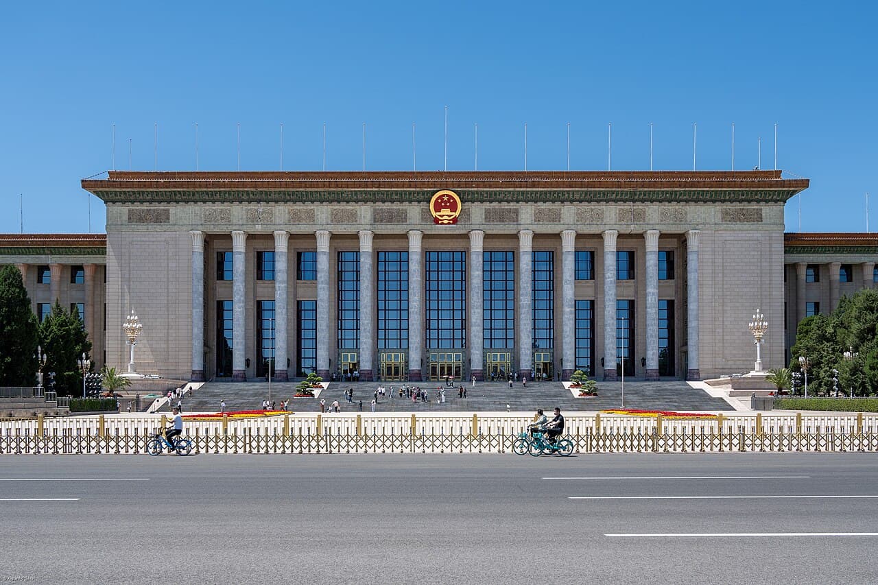 Great Hall of the People, a building in Beijing, China, under a blue sky.