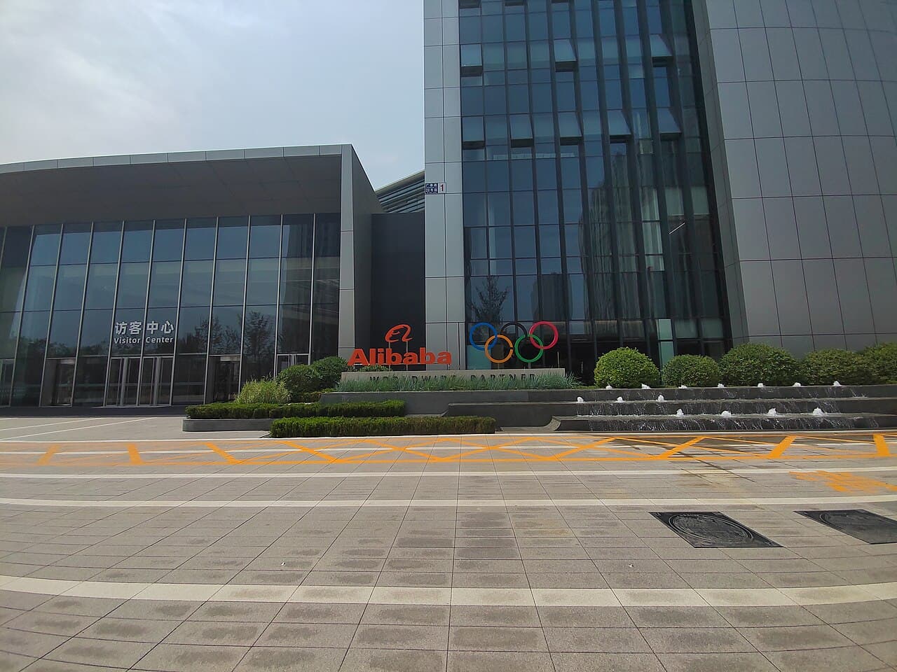 Exterior view of Alibaba Chaoyang Technology Park building with a visitor center sign.
